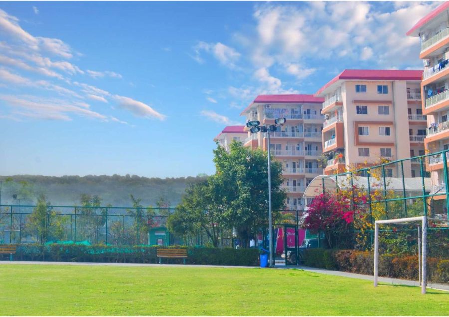 Football ground with residential towers and hills behind, River Valley Township