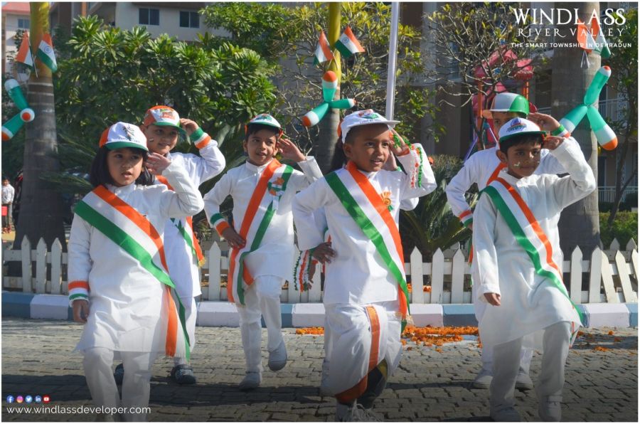 Children in white with tricolour sashes celebrating Independence Day at River Valley Township
