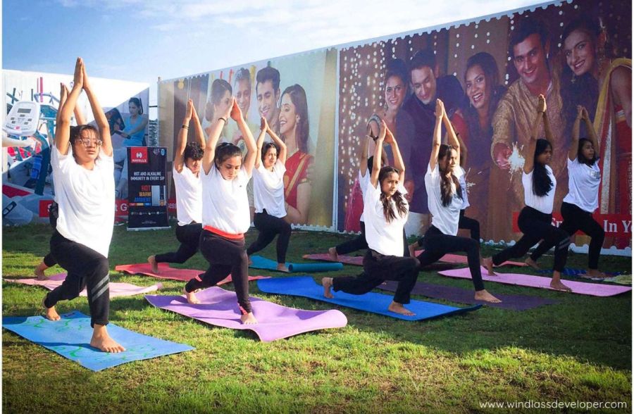 Residents doing yoga on mats on the lawn at River Valley Township