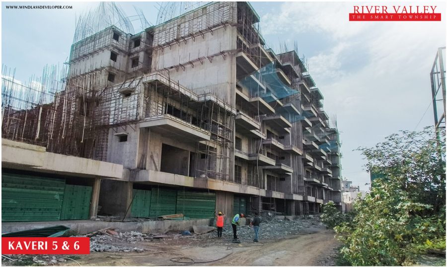 Construction progress at Kaveri Towers 5 and 6, River Valley Township, June 2026: street-side view of the towers